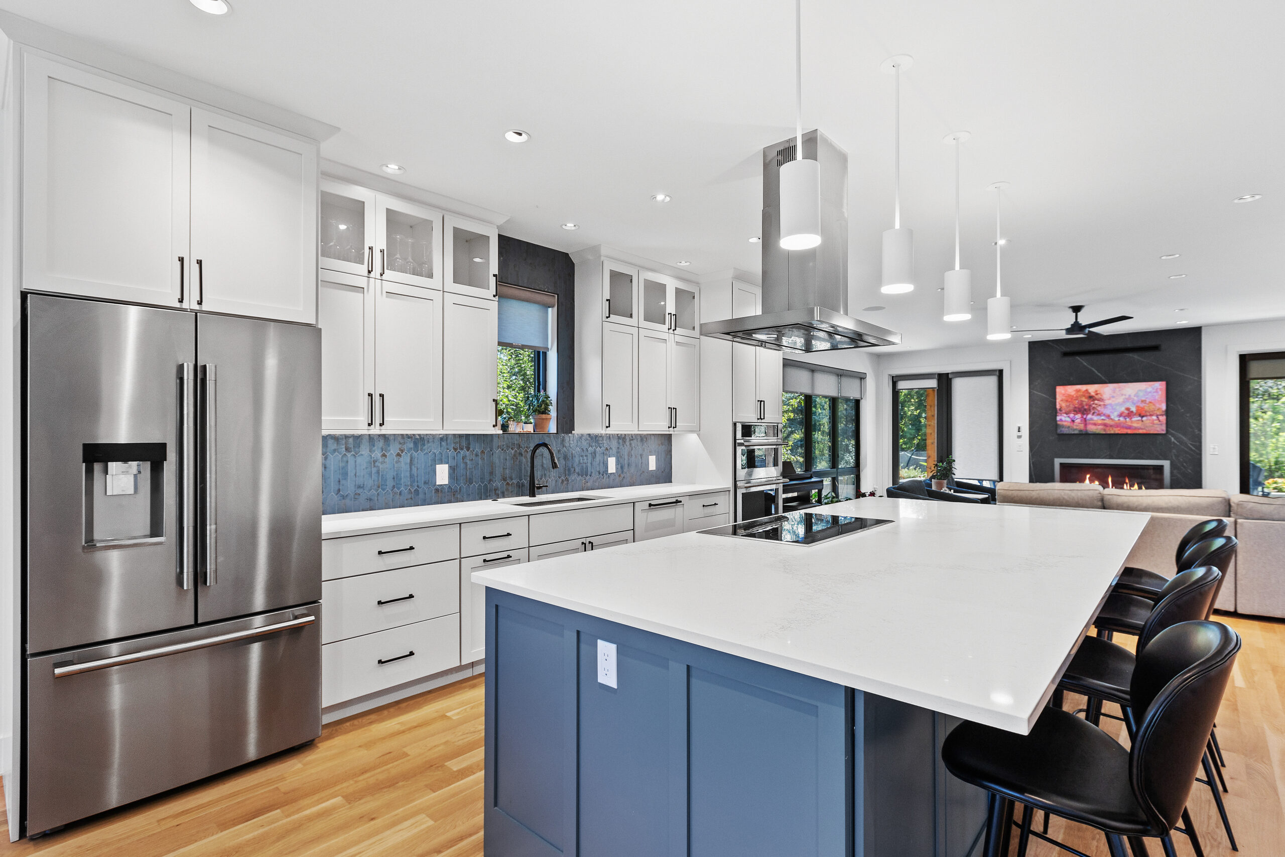 A custom remodeled kitchen with a stainless steel refrigerator, blue cabinets, and white counters.
