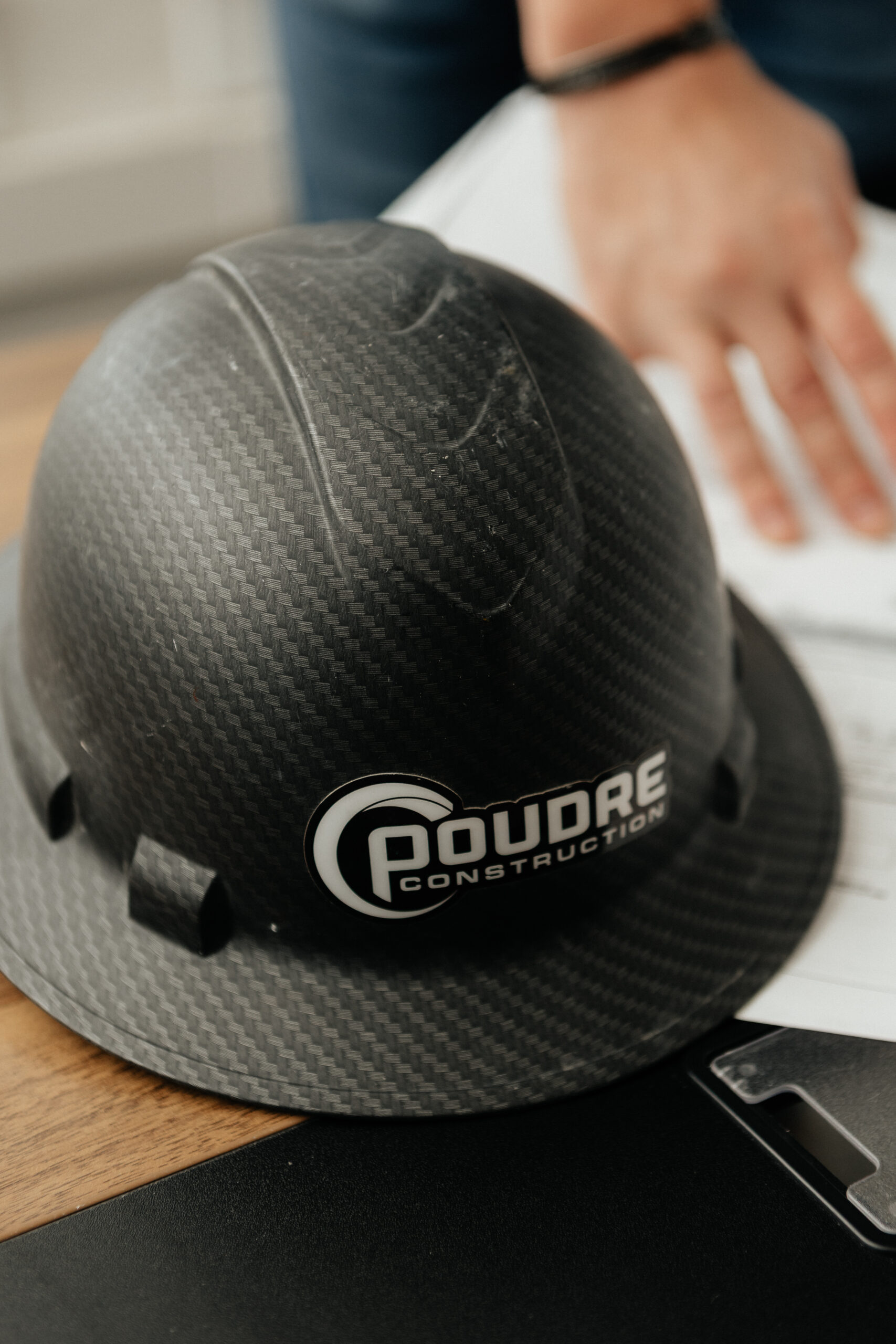 Hard hat with Poudre Construction logo.